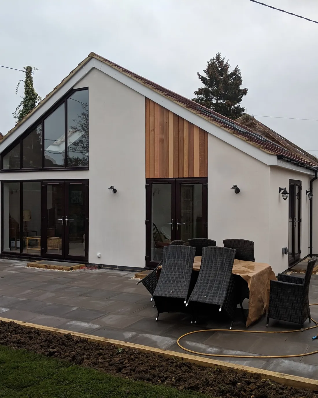 Remodelled bungalow with a glazed gable and timber-clad bay