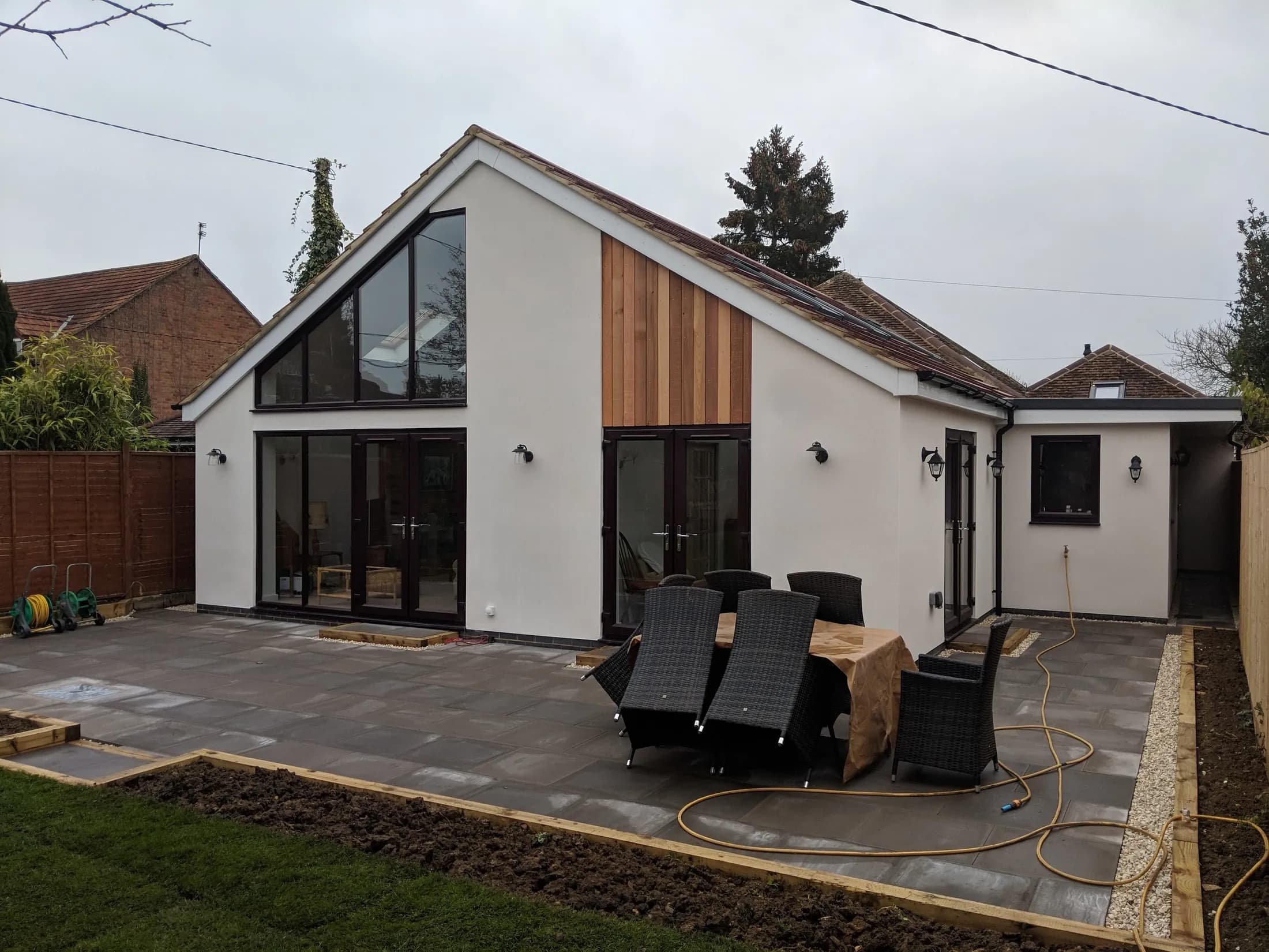 Remodelled bungalow with a glazed gable and timber-clad bay