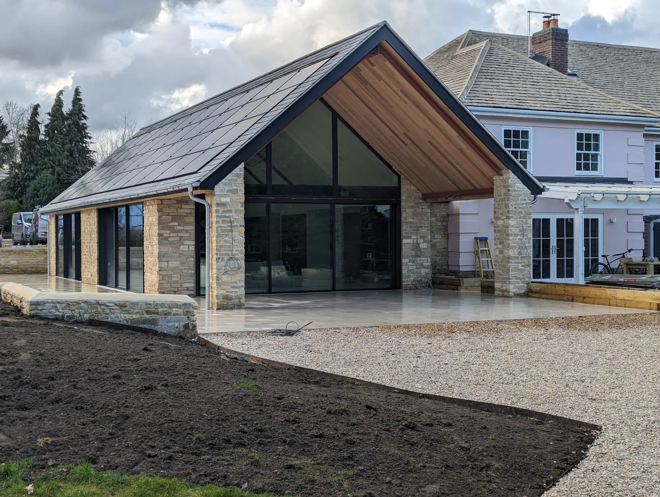 Stone new build with a fully glazed gable end and timber soffit