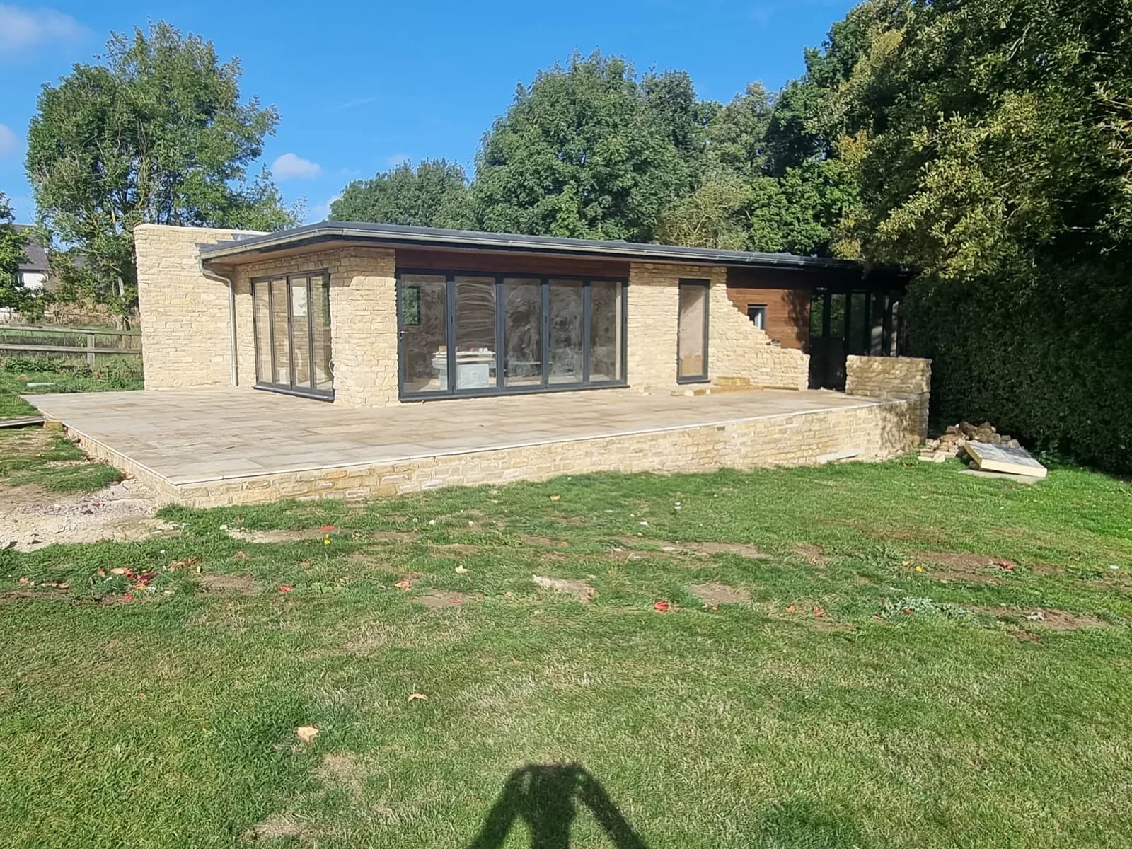 Contemporary stone extension with glazing onto a new patio